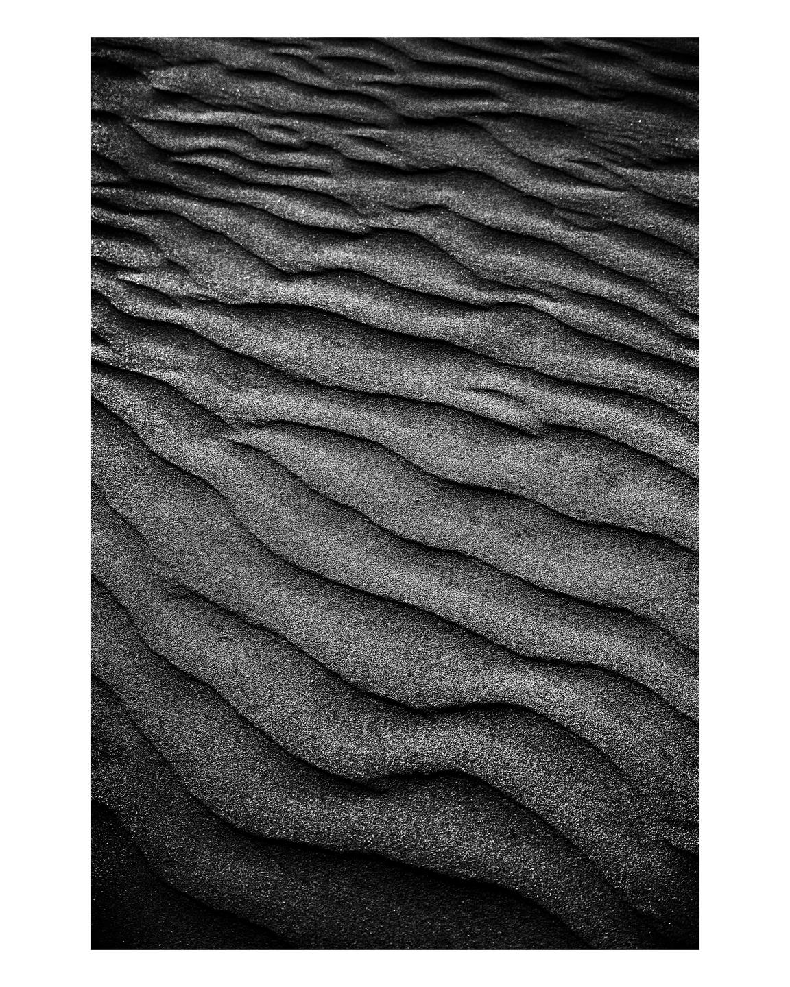 The image shows a close-up of sand ripples on a beach.