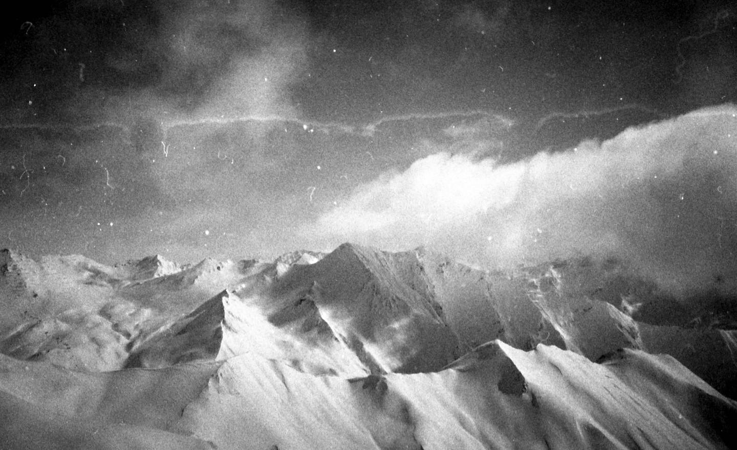 Snow-covered mountains are visible under a cloudy sky.