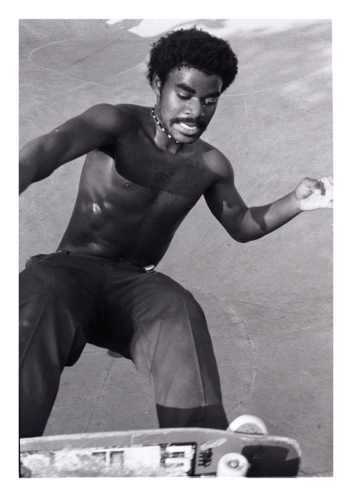 A man with a mustache and beard is skateboarding.