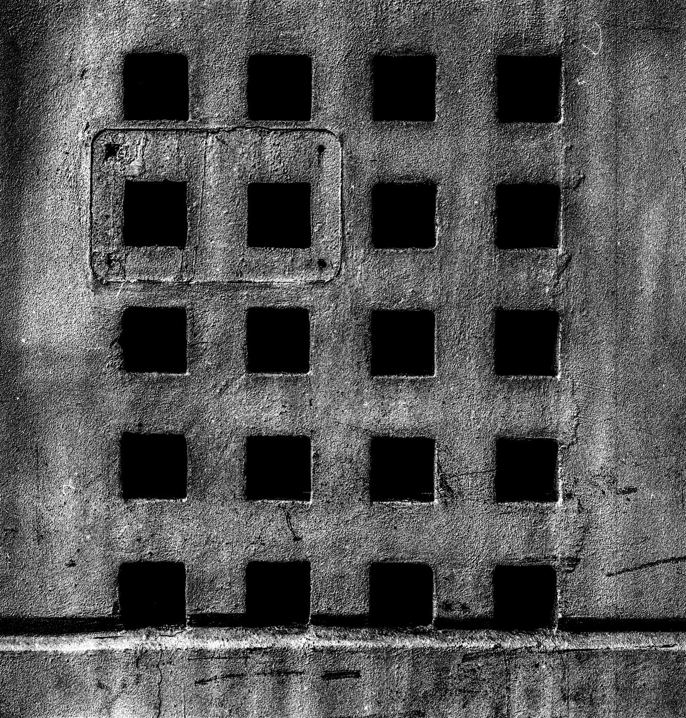 A grid of square holes is visible on a textured surface.