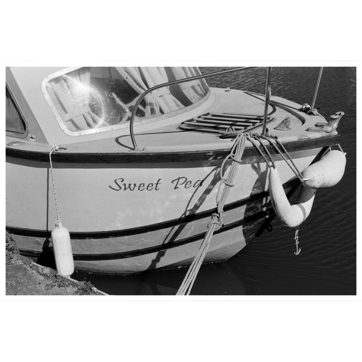A boat named "Sweet Pea" is docked in the water, with ropes and buoys visible.