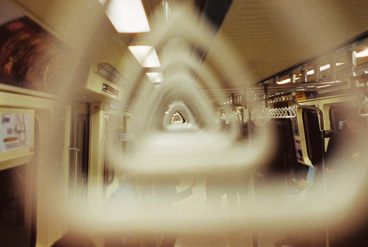 The interior of a subway car is visible through a blurry, tunnel-like effect.