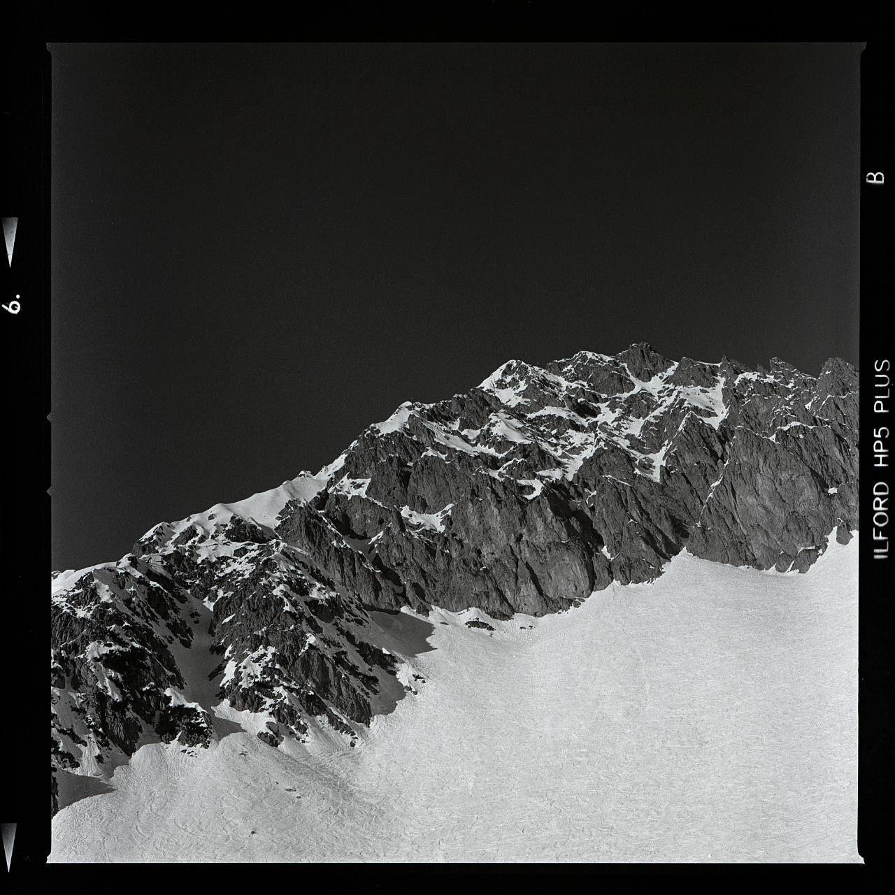 A snow-covered mountain range is visible under a dark sky.