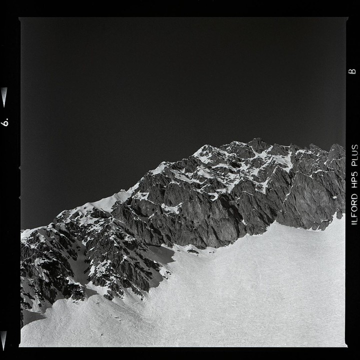 A snow-covered mountain range is visible under a dark sky.