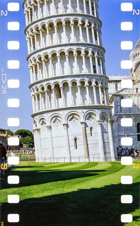 The Leaning Tower of Pisa stands tall with a bright blue sky in the background and green grass in the foreground.