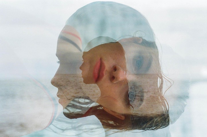 A triple exposure shows a woman's profile, a woman's face with red lips, and a woman's eye, all superimposed over a beach and ocean.