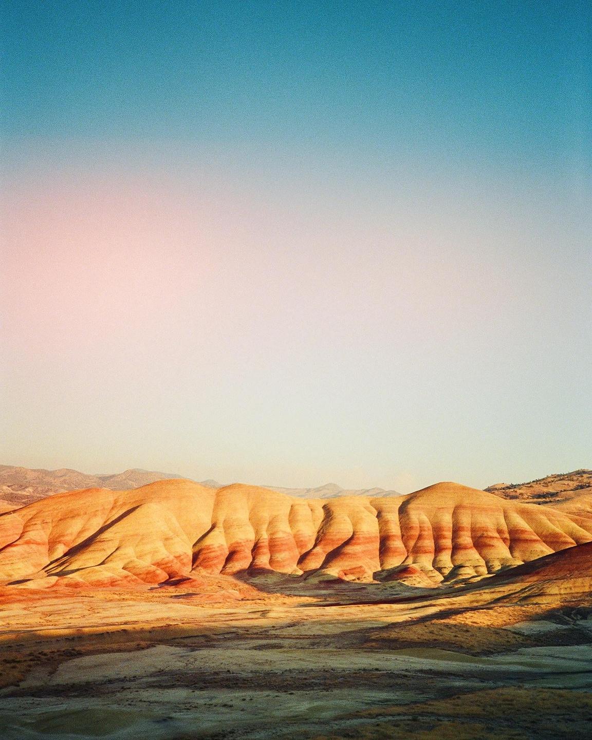 The Painted Hills are visible under a clear sky.