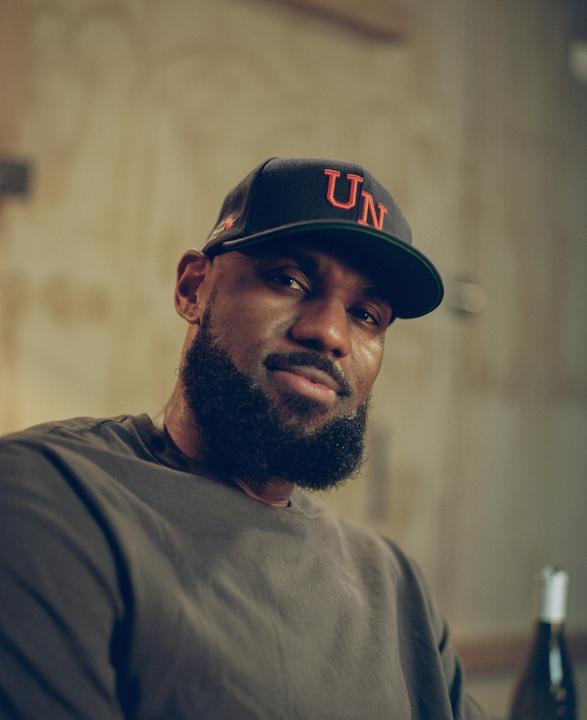 A man with a beard and a baseball cap looks at the viewer.