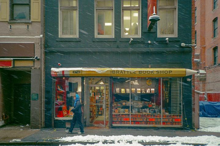 A person walks past the Brattle Book Shop during a snowstorm.