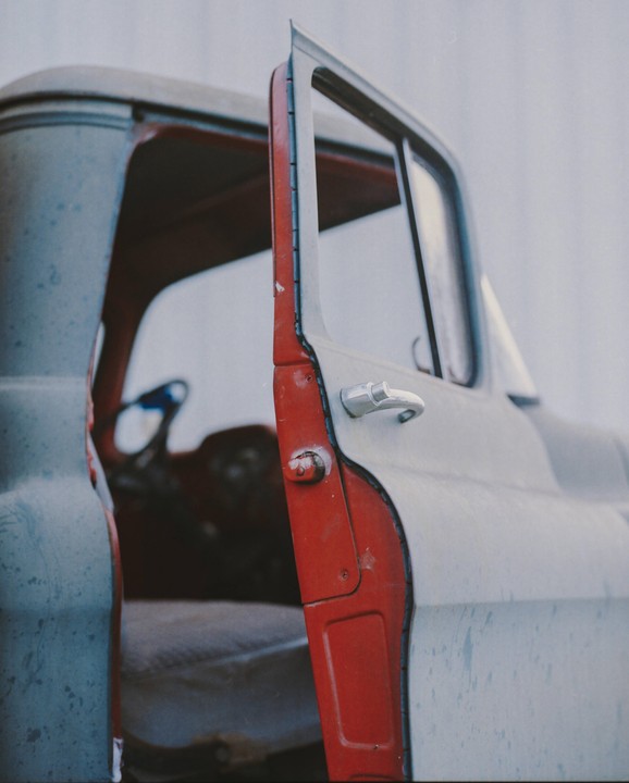 The open door of a red and gray truck is visible from the side.