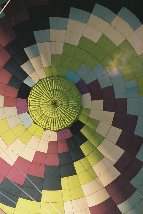 A hot air balloon is seen from the inside, with a flame visible near the top.