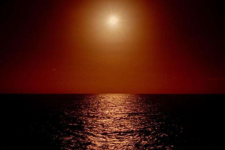 The sun shines brightly over the Atlantic Ocean, creating a shimmering path of light on the water.
