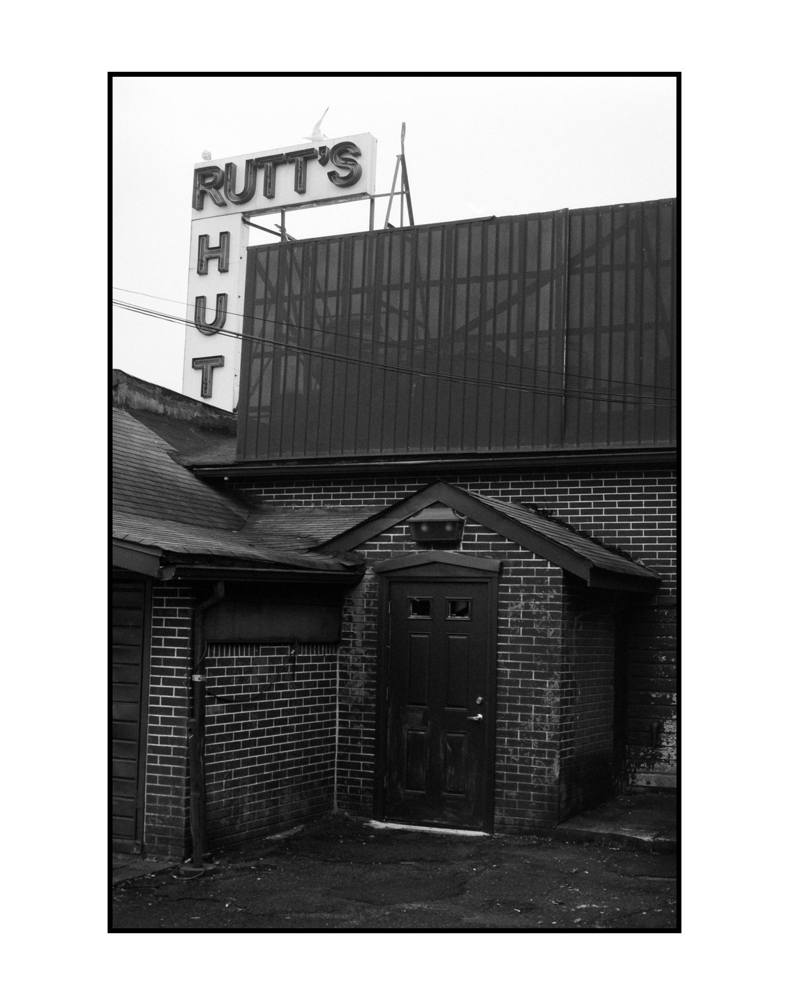 A brick building with a sign for Rutt's Hut is visible under a cloudy sky.