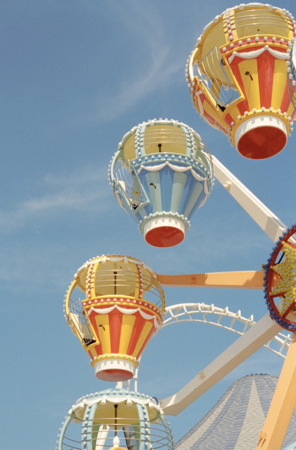 Three colorful hot air balloon gondolas are visible against a clear blue sky.