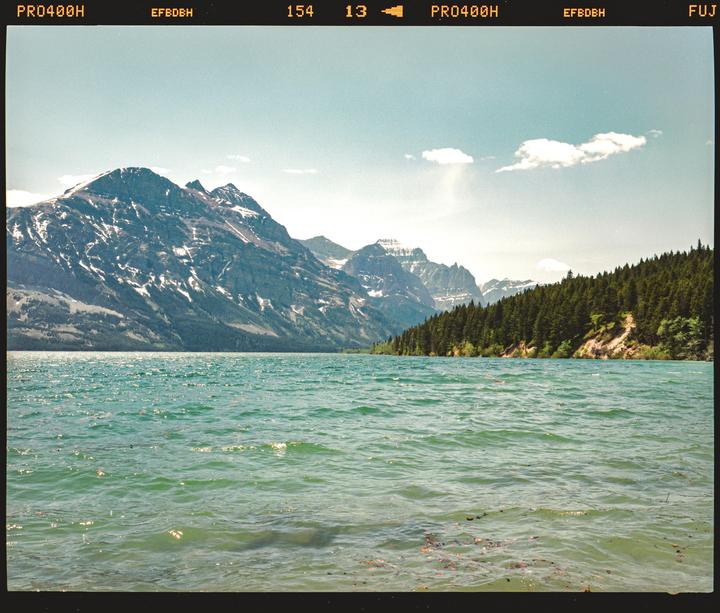 A large body of water with mountains and a forest in the background.