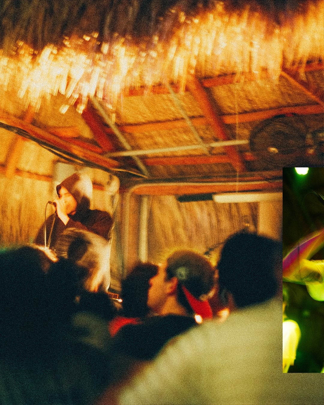 A blurry photo shows a musician performing on stage to a crowd under a thatched roof.