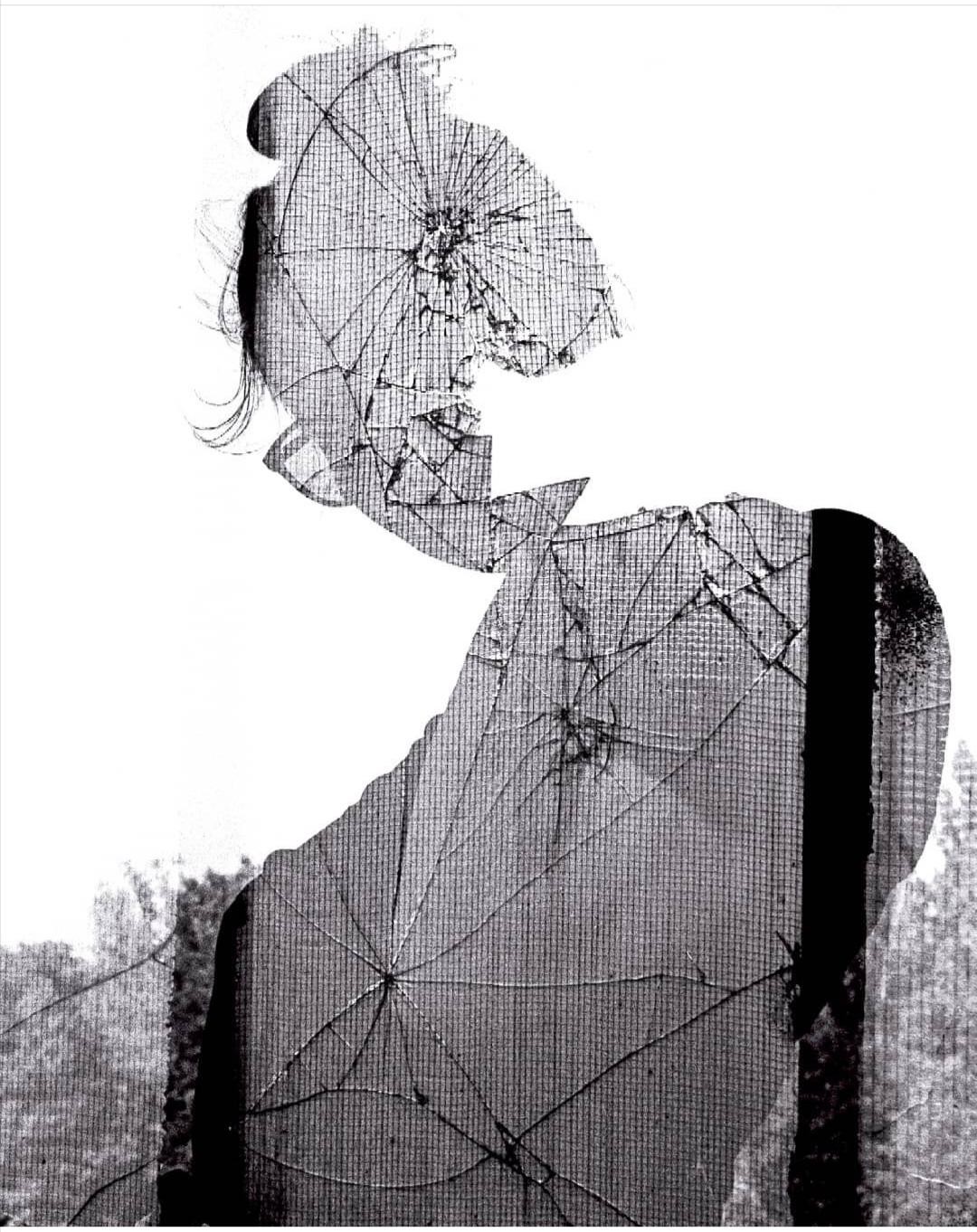 A double exposure shows a woman's silhouette with a broken glass texture overlaid on a forest.