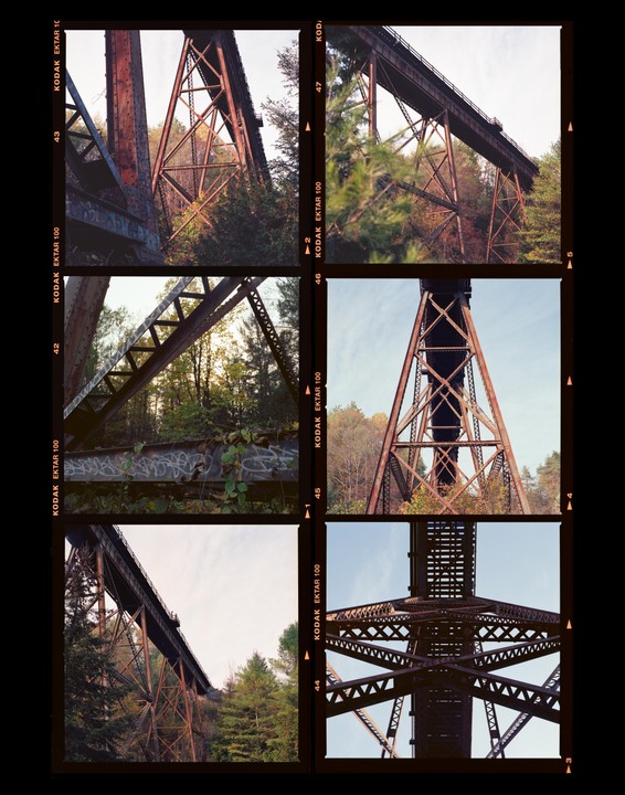 A contact sheet displays six photographs of a large, rusty metal bridge structure surrounded by trees.