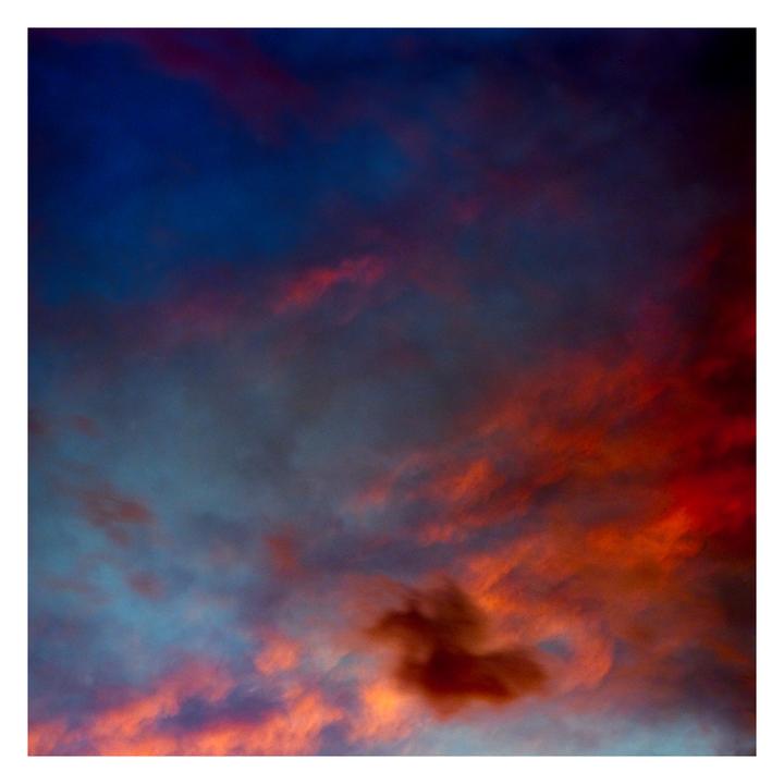 The sky is filled with dramatic clouds in shades of blue, orange, and red.