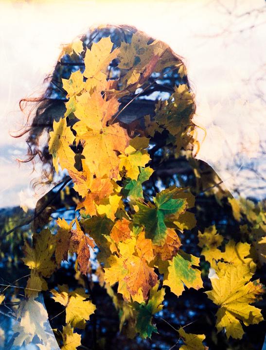 A double exposure shows a woman's silhouette overlaid with autumn leaves.