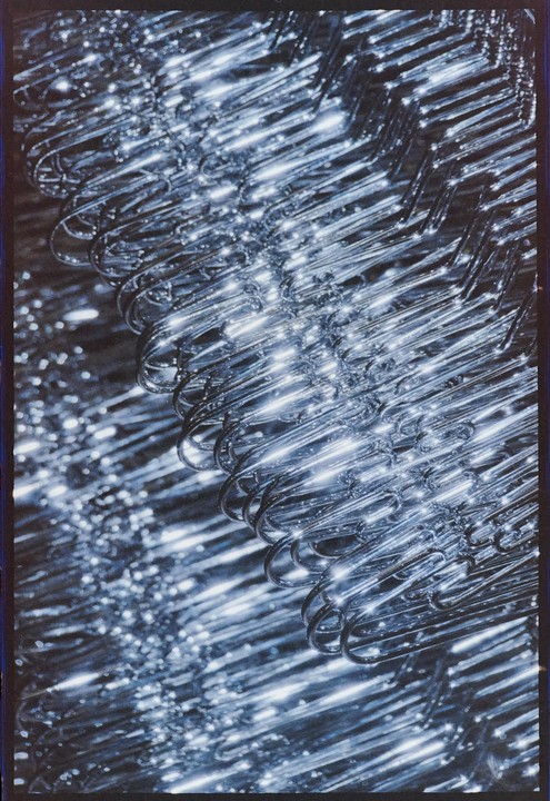 A close-up shows a stack of shiny metal coat hangers.