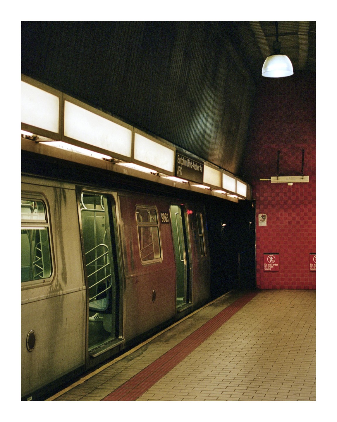 A subway train with open doors waits at a station platform.