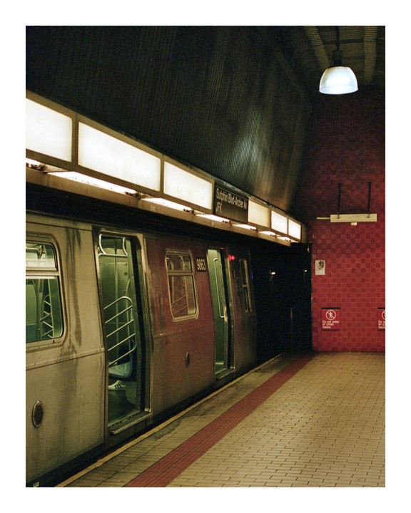 A subway train with open doors waits at a station platform.