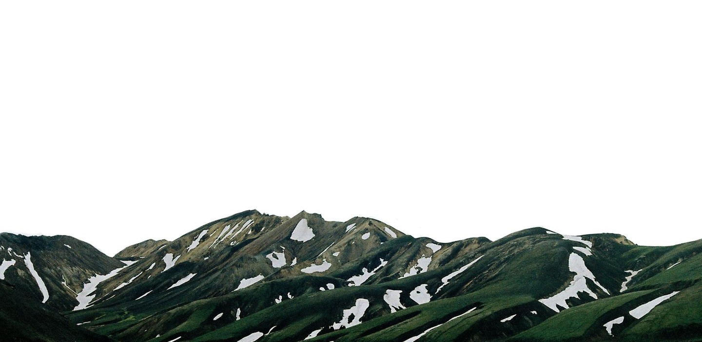 A landscape view shows green mountains with patches of snow under a bright sky.