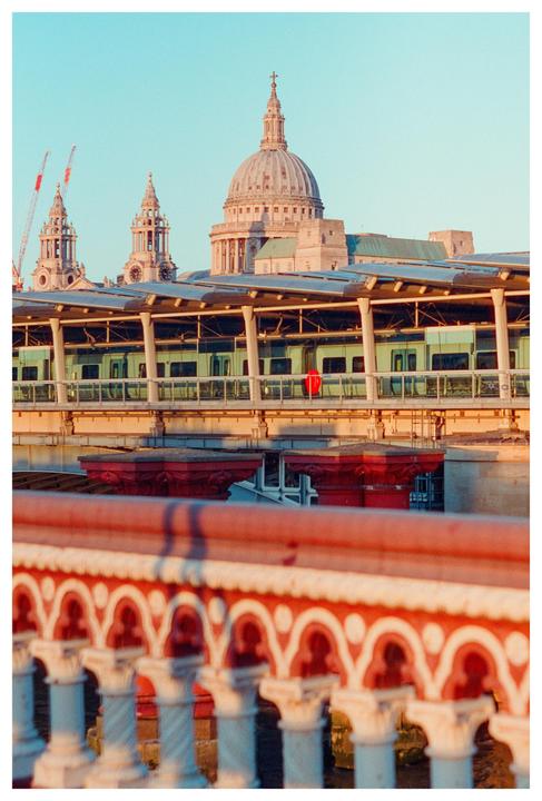 A train passes on a bridge in front of St Paul's Cathedral in London.