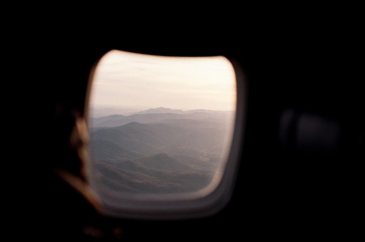 A view of hazy mountains from an airplane window.
