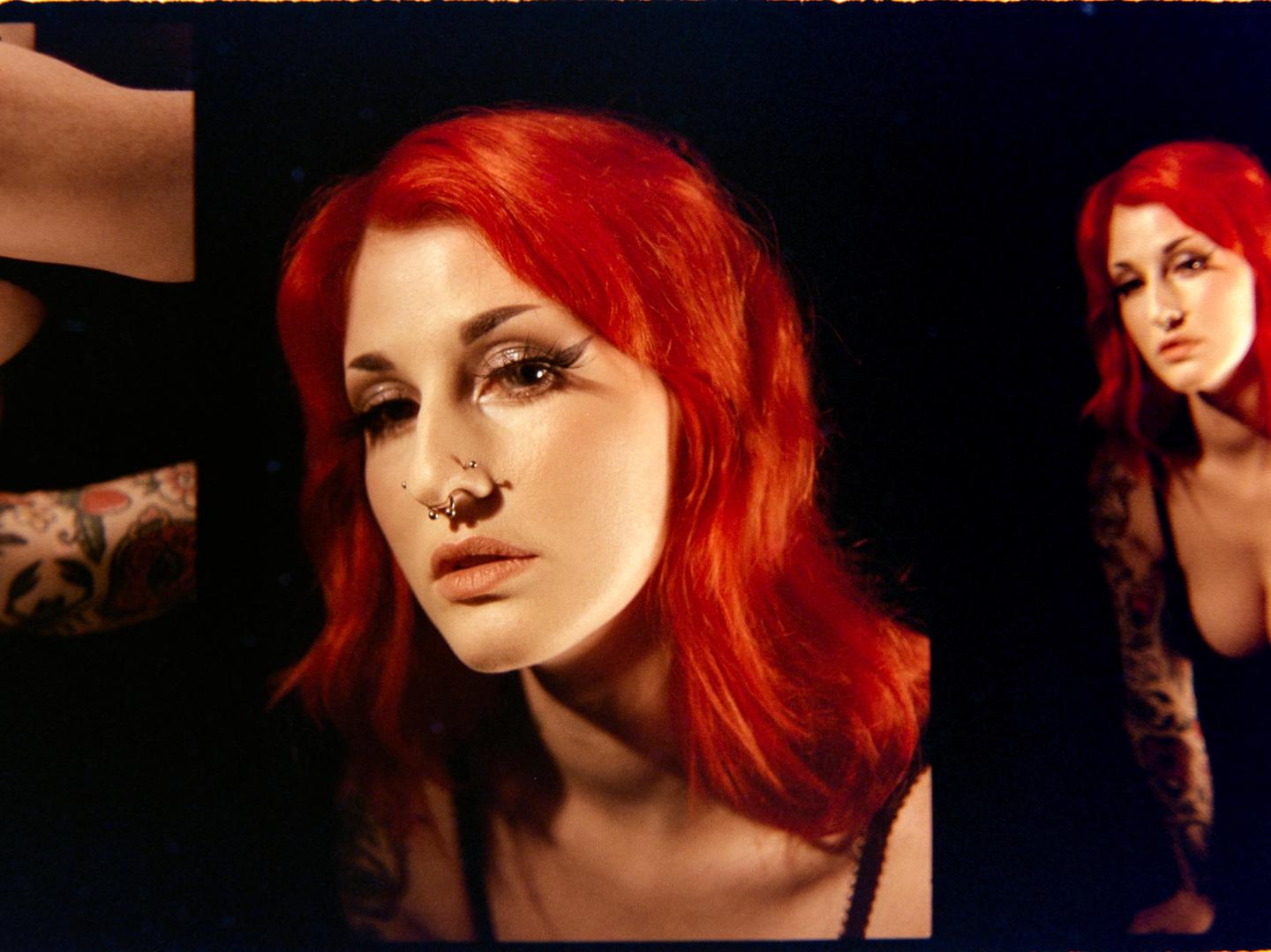 A woman with red hair and a nose piercing is shown in a studio portrait, with a second, blurry image of her visible to the right.