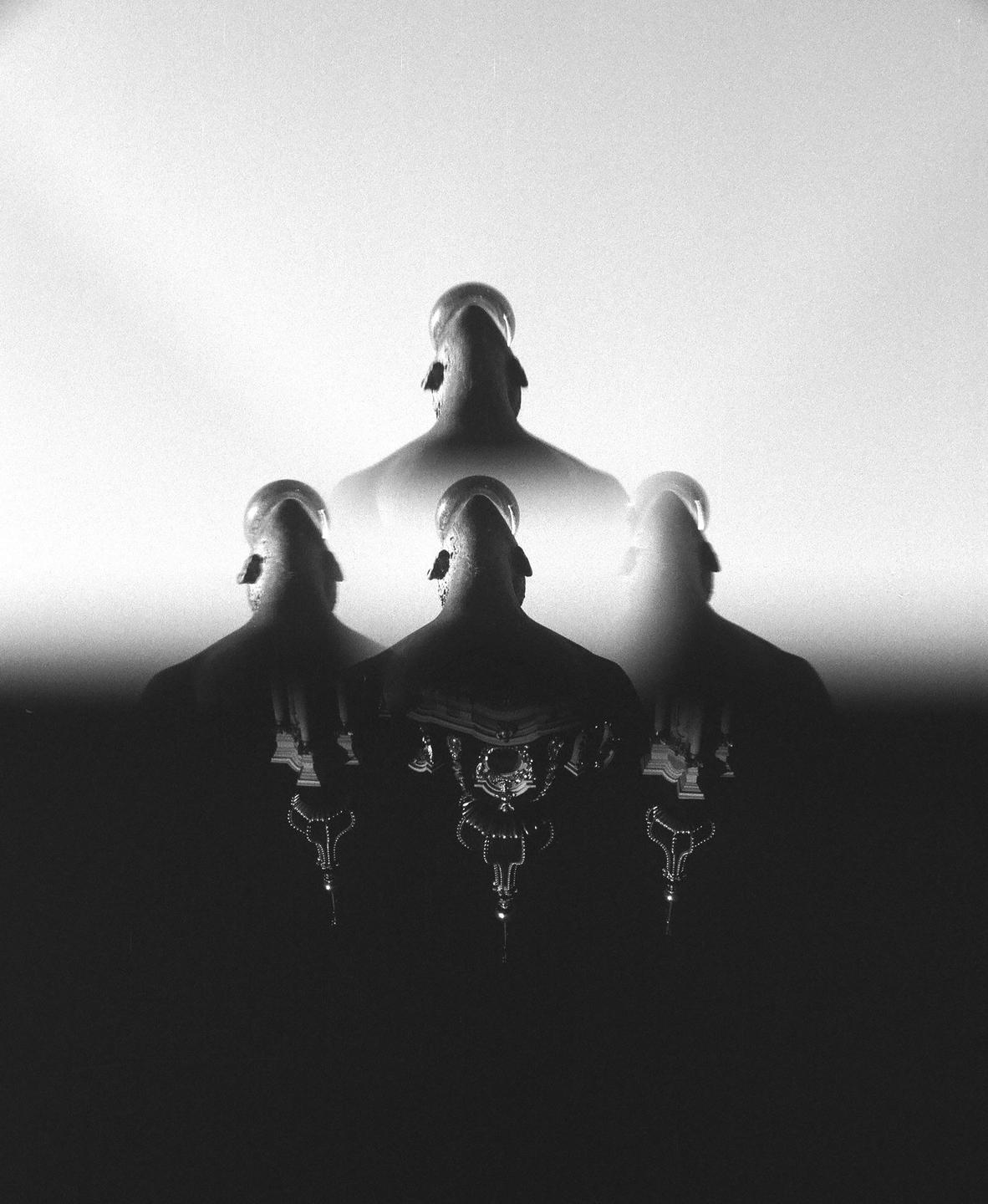 Four figures with their backs to the viewer are visible in a black and white double exposure.