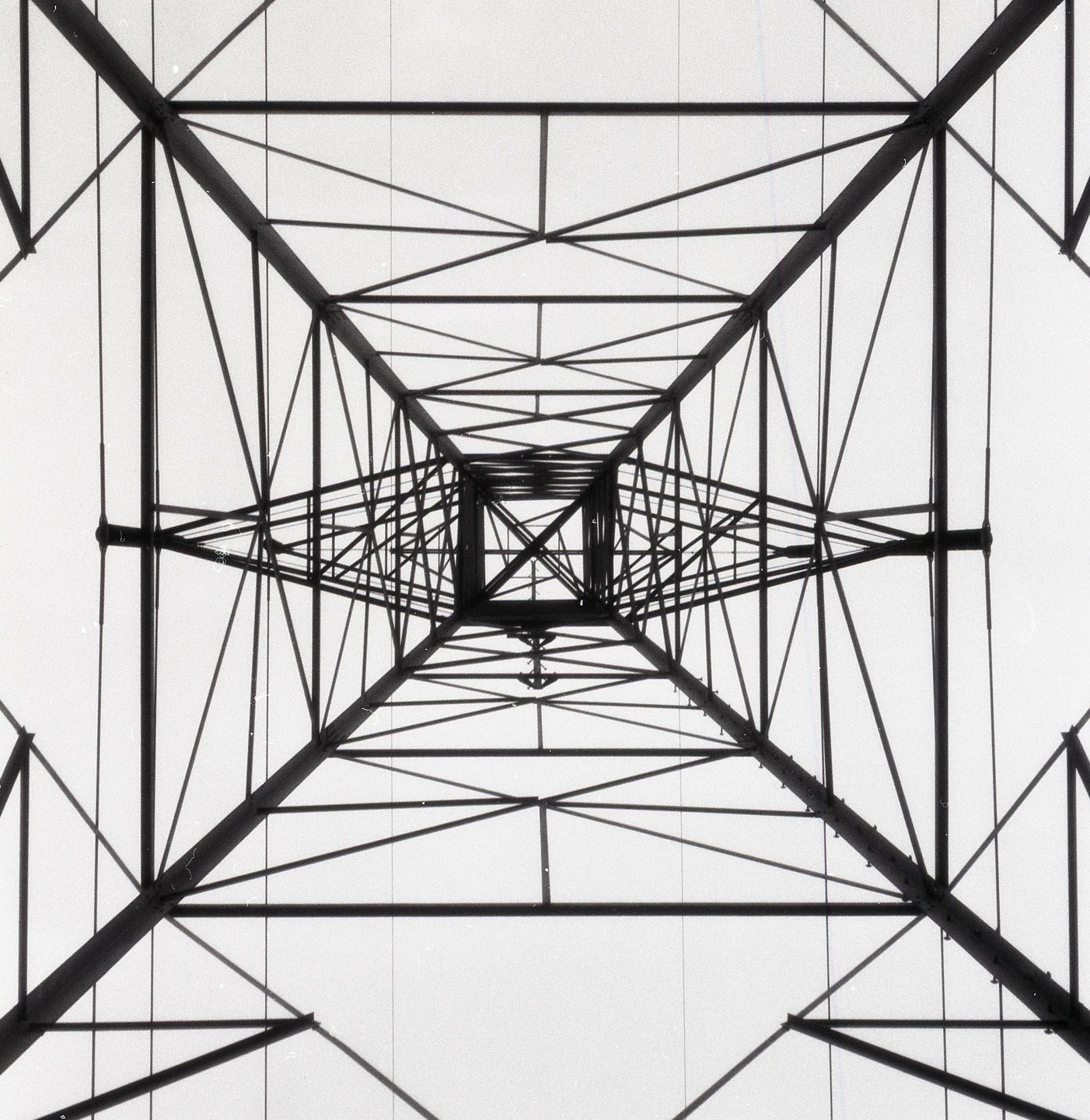 A low-angle view shows the converging lines of a metal structure against a bright sky.