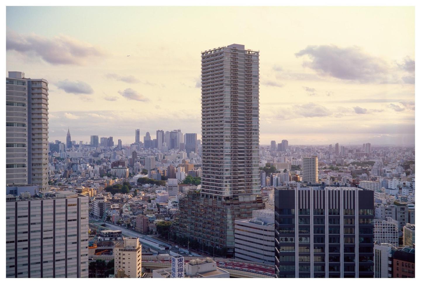 A panoramic view of a city skyline with numerous buildings and a cloudy sky.