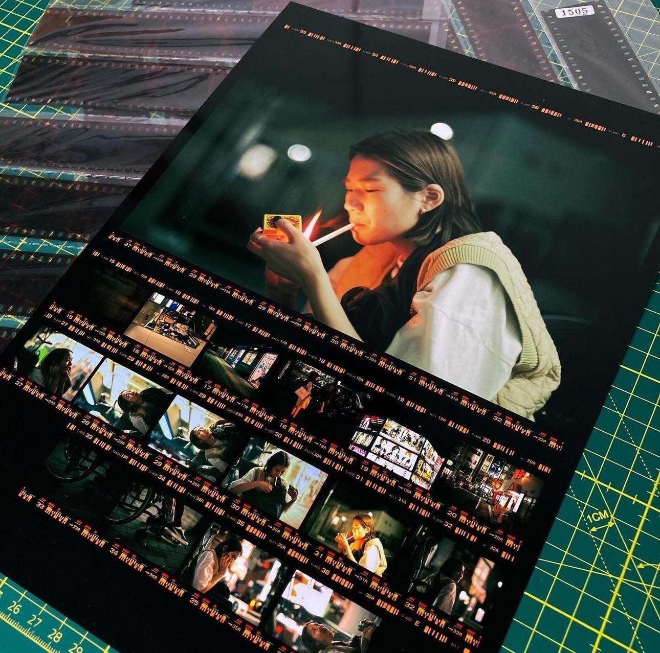A contact sheet is printed with one frame enlarged to show a woman lighting a cigarette.