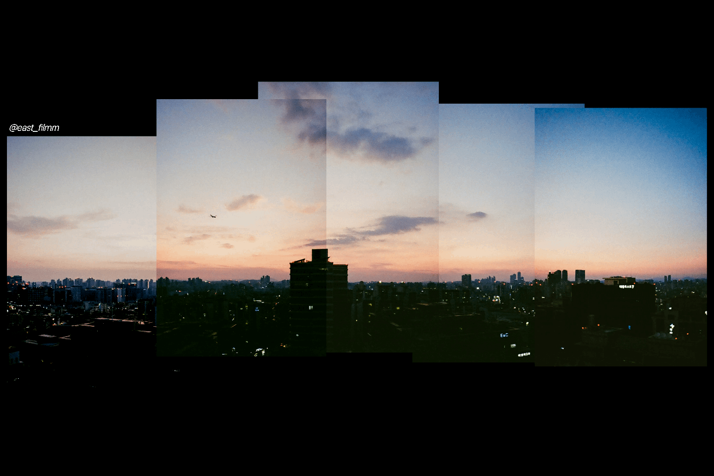 A panoramic view of a city skyline at dusk with an airplane flying in the distance.