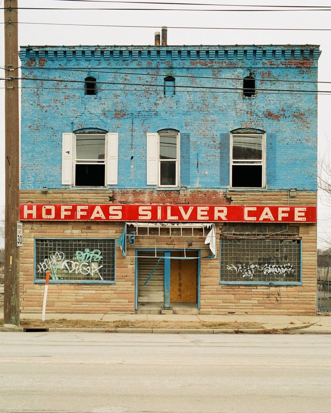 A two-story brick building with a red sign that reads "HOFFAS SILVER CAFE" is visible from the street.