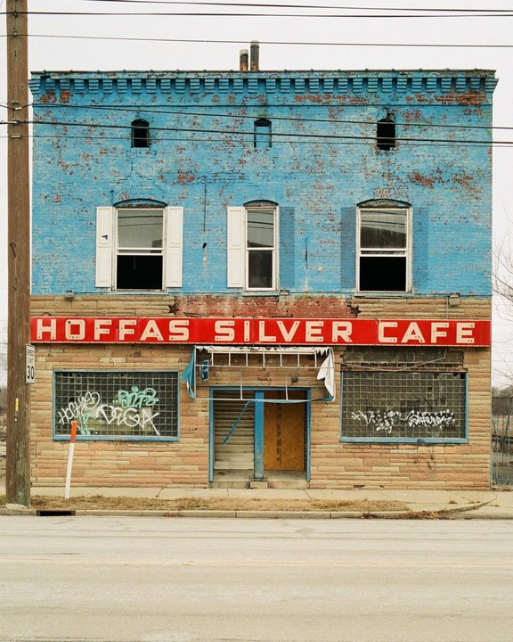 A two-story brick building with a red sign that reads "HOFFAS SILVER CAFE" is visible from the street.