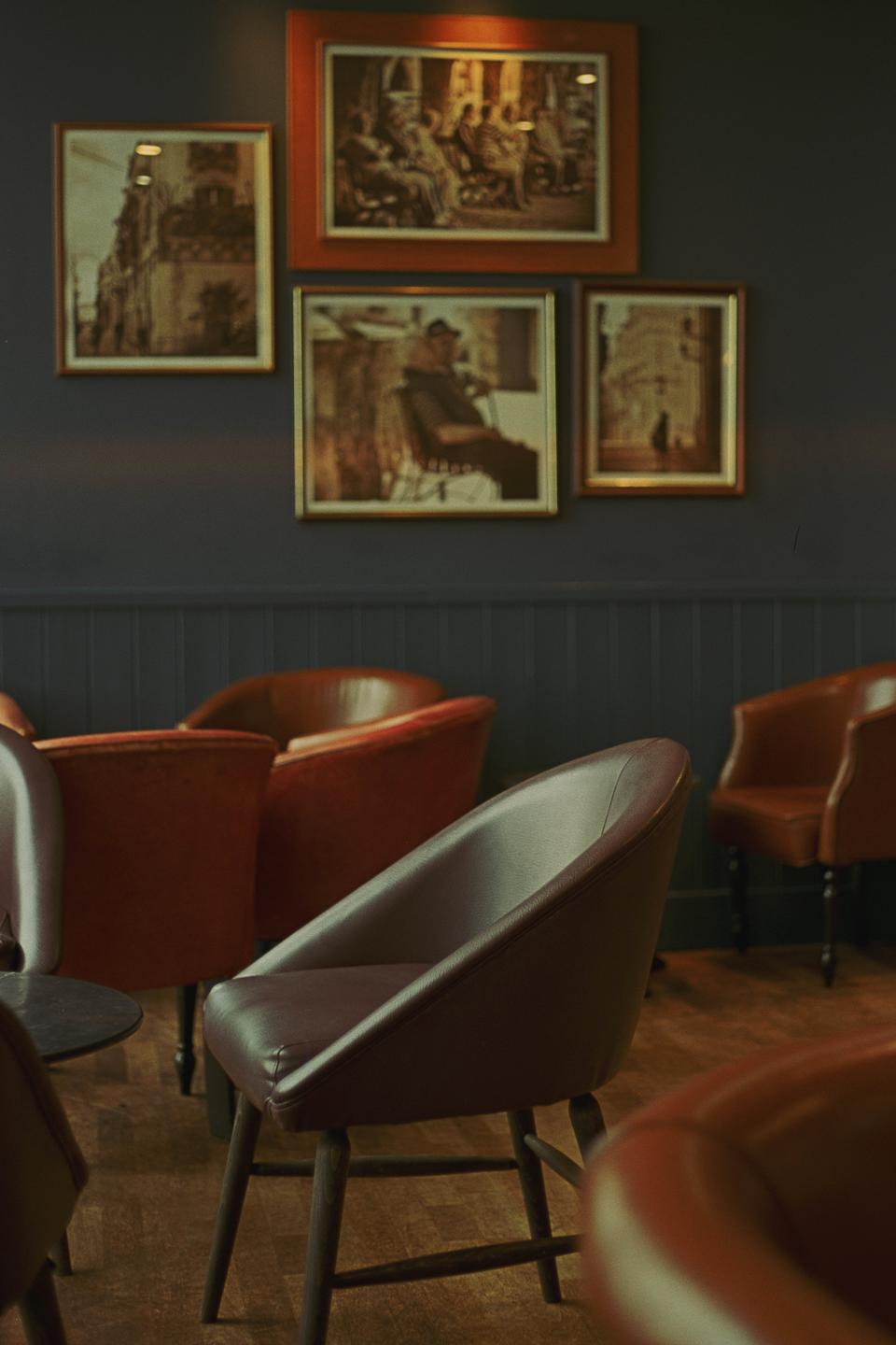 A room with several chairs and framed pictures on the wall is visible.