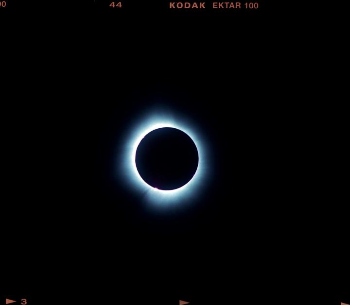 A total solar eclipse is visible against a dark sky.