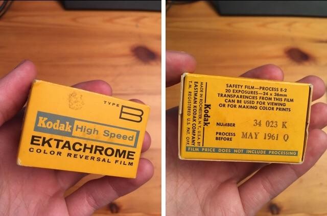A hand holds a small yellow box of Kodak High Speed Ektachrome color reversal film, with text indicating it expires in May 1961.