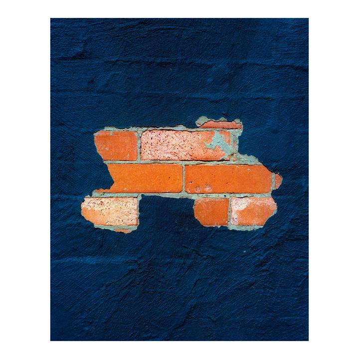A section of exposed brick wall is visible through peeling dark blue paint.