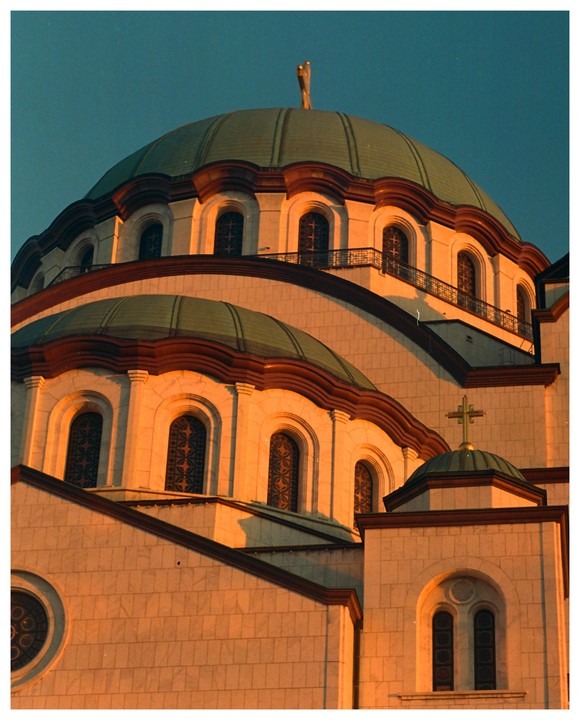 A large domed building with many windows is illuminated by golden light.