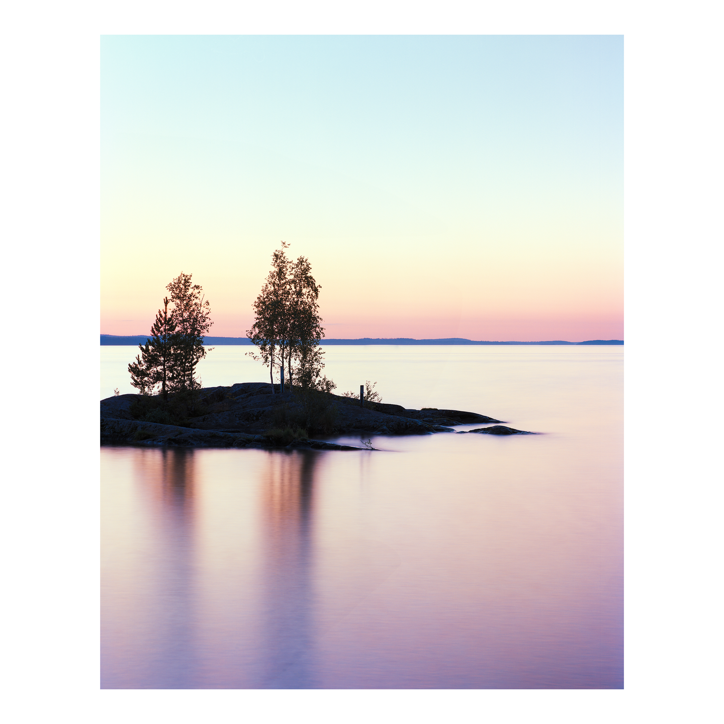 Two trees stand on a small rocky island in a calm lake under a pastel sunset sky.