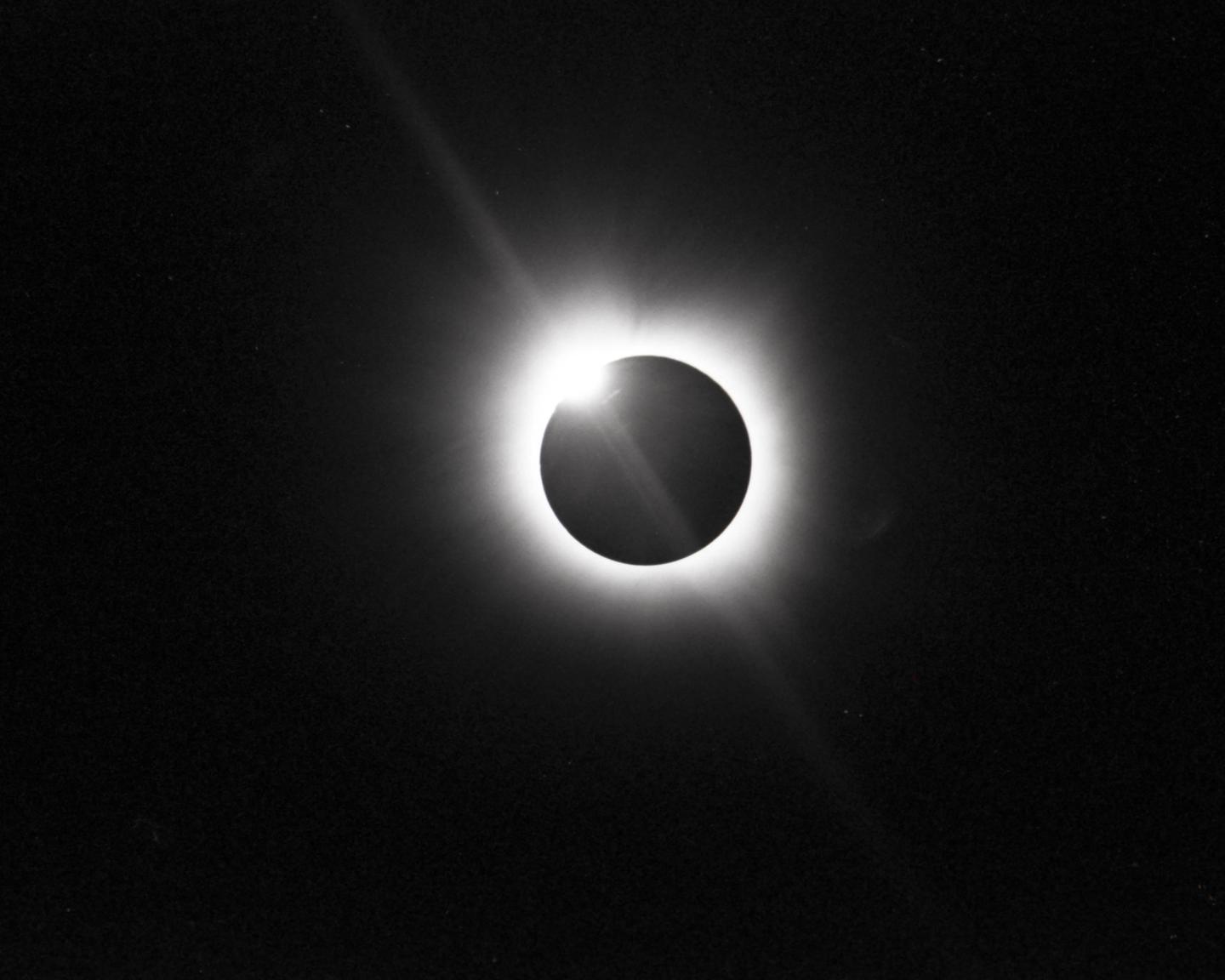 A total solar eclipse is visible in the night sky.