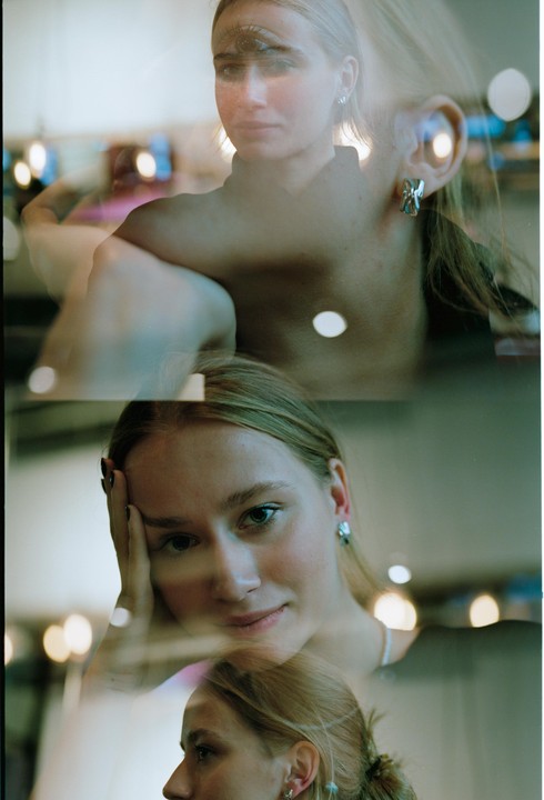 A woman is shown in a triple exposure with one image of her face with an eye on her forehead, another of her smiling, and a third of her in profile.