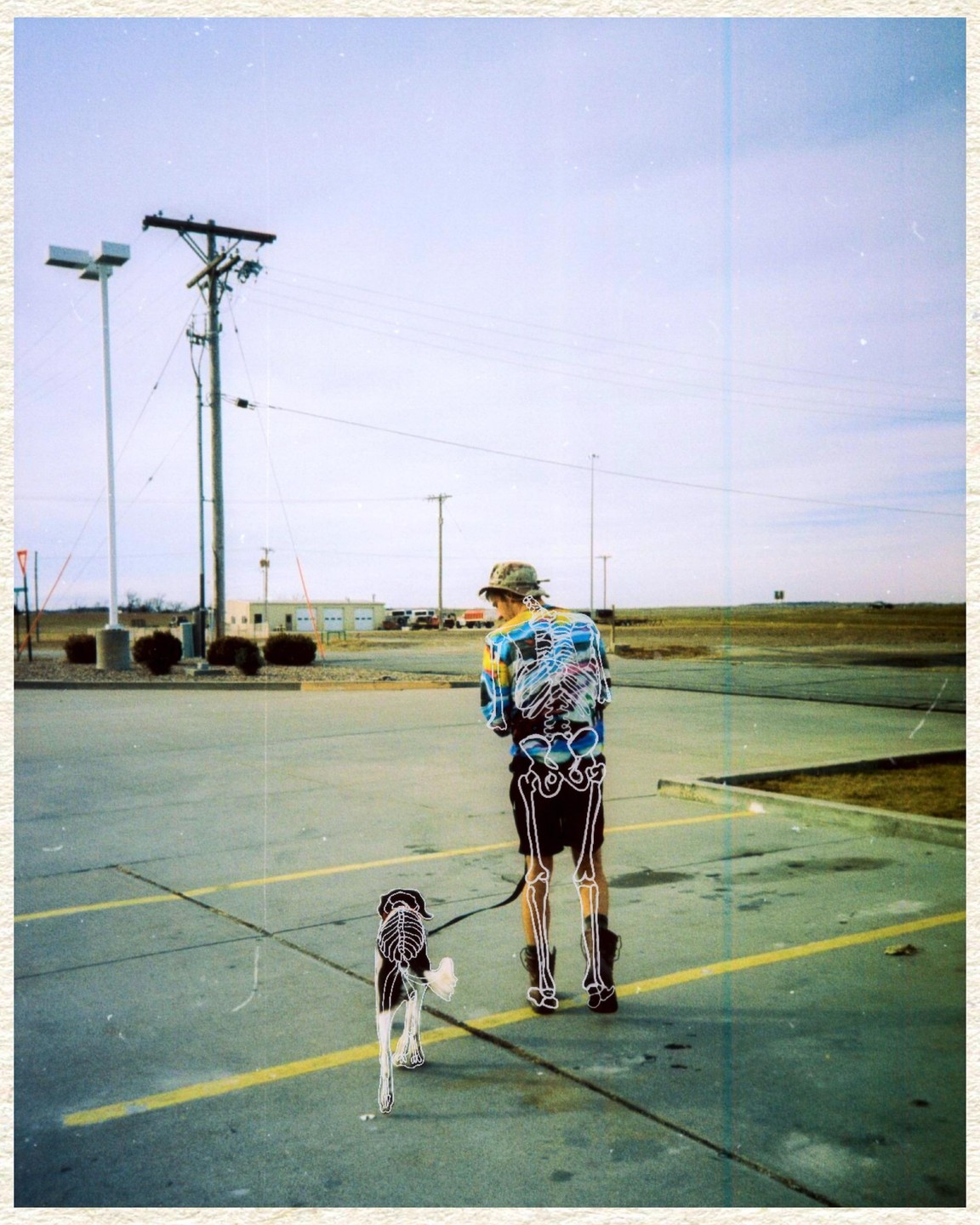 A man and a dog with skeleton outlines are walking on an asphalt lot.
