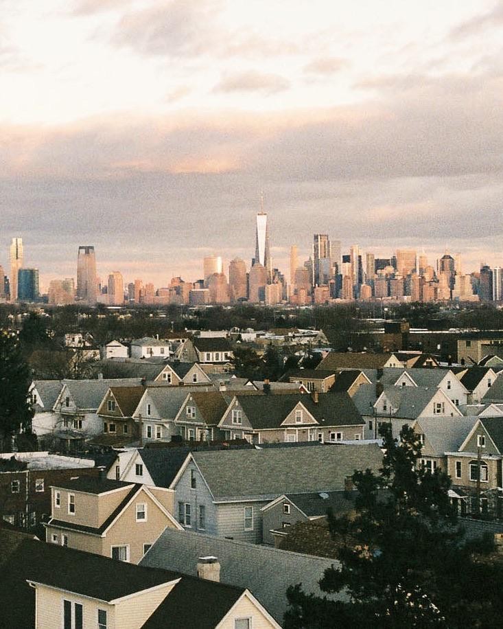 A cityscape with many buildings is visible behind a neighborhood of houses.