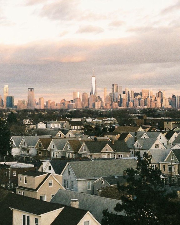 A cityscape with many buildings is visible behind a neighborhood of houses.
