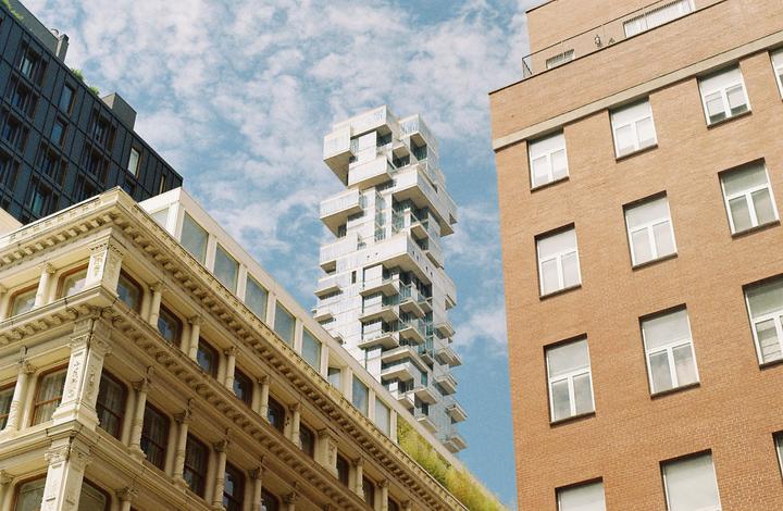 Three buildings of different architectural styles are visible against a cloudy sky.